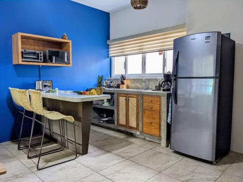 a kitchen with a stainless steel refrigerator and wooden cabinets at 2BR -Water at Mikasa- Fast WIFI, King beds, AC, Near beach, Pool in Puerto Escondido