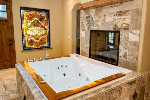 a large tub in a bathroom with a stained glass window at Mediterranean Mountain Memories in Colorado Springs