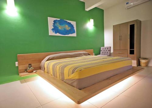 una camera da letto con un grande letto con una parete verde di 2BR -Water at Mikasa- Fast WIFI, King beds, AC, Near beach, Pool a Puerto Escondido