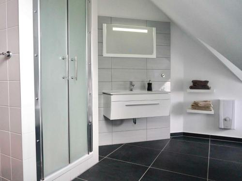 La salle de bains est pourvue d'un lavabo et d'un miroir. dans l'établissement Apartment Rotes Haus, à Kröslin
