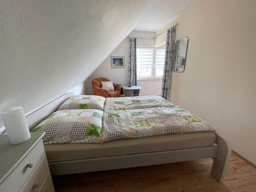 a bedroom with a bed and a chair at Apartment Rotes Haus in Kröslin