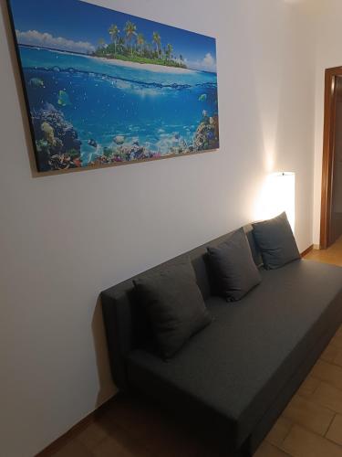 a couch in a living room with a painting on the wall at la casina accogliente in Pisa