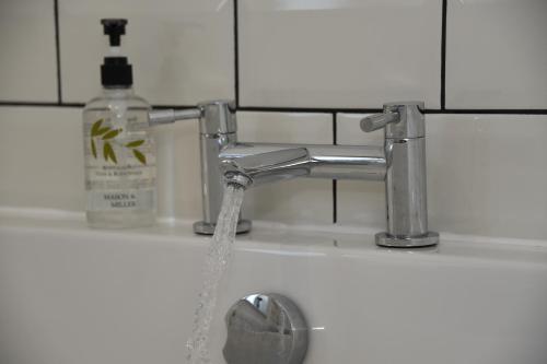 a sink with water coming out of a faucet at Maen Llwyd in Llanyre