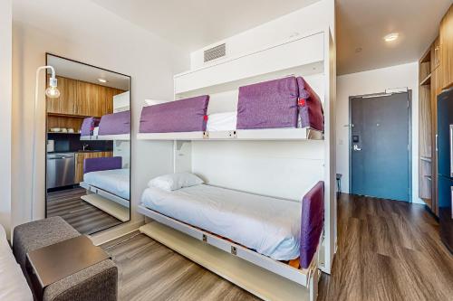 a room with two bunk beds with purple accents at Canyons Resort Village #129 in Park City