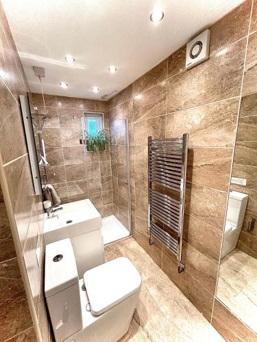 a bathroom with a toilet and a shower and a sink at Holland House in New Brighton