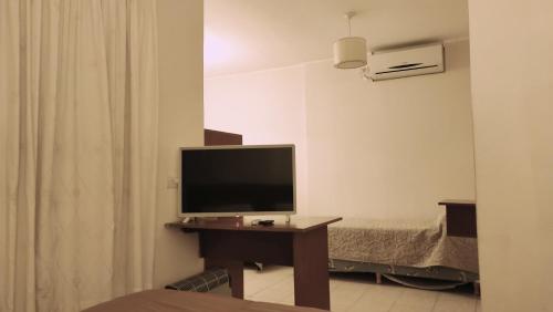 Habitación con TV en una mesa con cama en Coronado Hotel en Mina Clavero