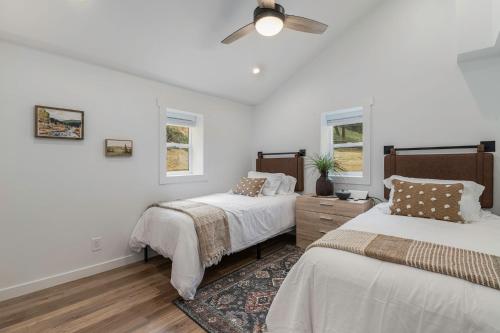 a bedroom with two beds and a ceiling fan at Welcome! 4 bedroom (6 bed) 3 bath River House in Sedalia