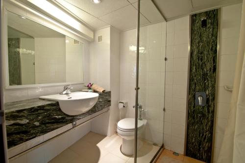 a bathroom with a sink and a toilet and a mirror at Golden Beach Hotel Pattaya in Pattaya Central