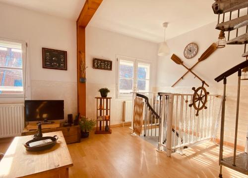 a living room with a table and a tv at Le Gîte du Phare vue sur mer in Cayeux-sur-Mer