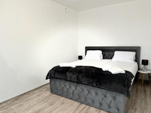 czarne łóżko z białą pościelą i poduszkami w obiekcie Sky apartments 508 w Pilznie