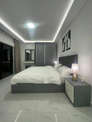 a bedroom with a bed and a table with a lamp at cozy rooftop near al services 23 in Rujm ash Sharāʼirah