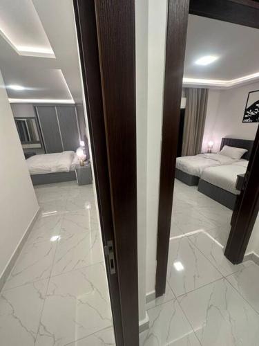 a room with two beds and a hallway with two beds at cozy rooftop near al services 23 in Rujm ash Sharāʼirah