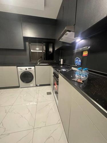 a kitchen with a black and white counter top at cozy rooftop near al services 23 in Rujm ash Sharāʼirah