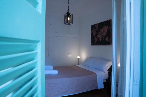 małą sypialnię z łóżkiem w niebieskim pokoju w obiekcie Sigma Acropolis Upstairs w Atenach