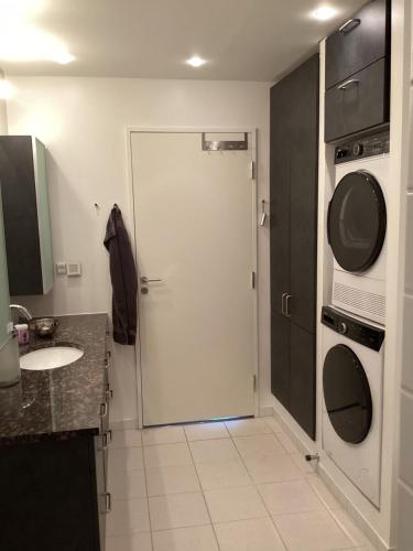 een badkamer met een witte deur en een wasmachine bij Unik udsigt og beliggenhed in Aarhus