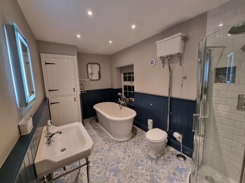 a bathroom with a tub and a sink and a toilet at Dove View Hartington: luxury 3 bed cottage in Hartington