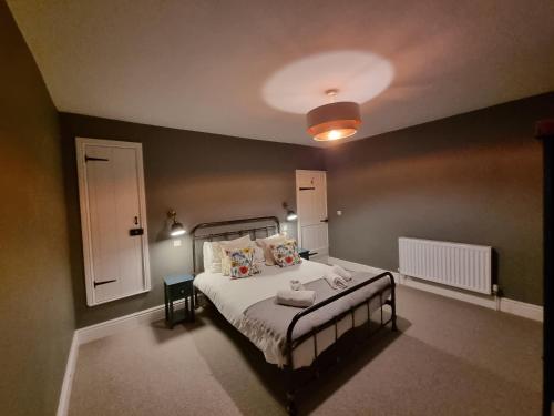 a bedroom with a bed and a light on the ceiling at Dove View Hartington: luxury 3 bed cottage in Hartington