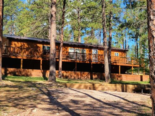 a large wooden house with a balcony in the woods at HTR Black Hills Resort in Rockerville