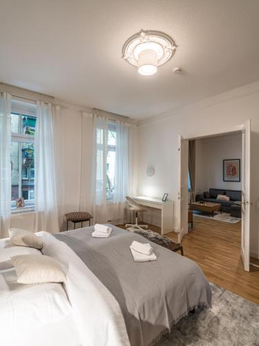 a bedroom with a large bed and a living room at Hochwertige Altbauwohnung im modernen Stil in Wiesbaden - Küche - Terrasse - WLAN - Zentral in Wiesbaden