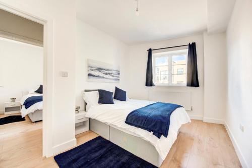 a white bedroom with a bed and a window at 2 Bedroom Apartment in Brixton with Wi-Fi in London