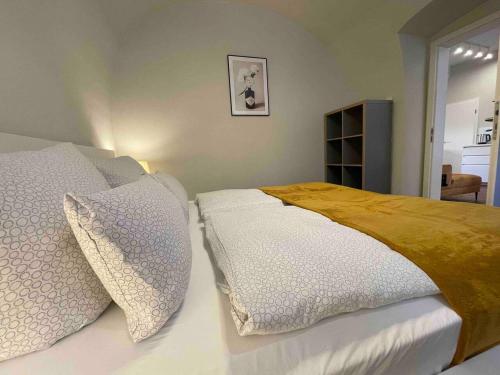 1 dormitorio con 1 cama con sábanas y almohadas blancas en Design-Suite Am Markt, en Pirna