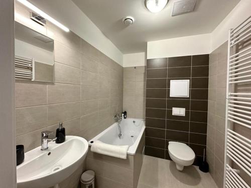 łazienka z umywalką, wanną i toaletą w obiekcie Sky apartments 508 w Pilznie