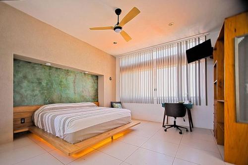 a bedroom with a bed and a fan and a desk at Penthouse -Sky at Mikasa- Fast wifi, King Bed, AC & Pool in Puerto Escondido