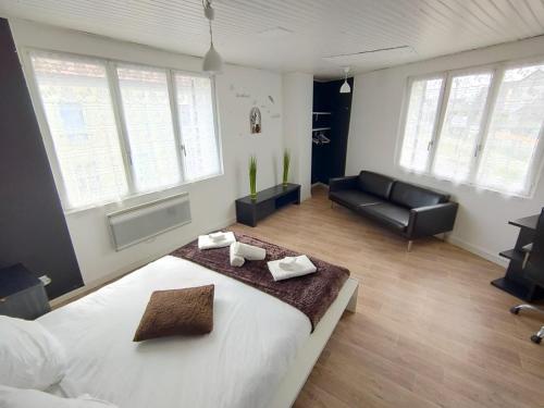 a bedroom with a large bed and a couch at Pause entre deux Meaux ► Proche Disneyland Paris ► WiFi ► Netflix ► 24/24h in Penchard