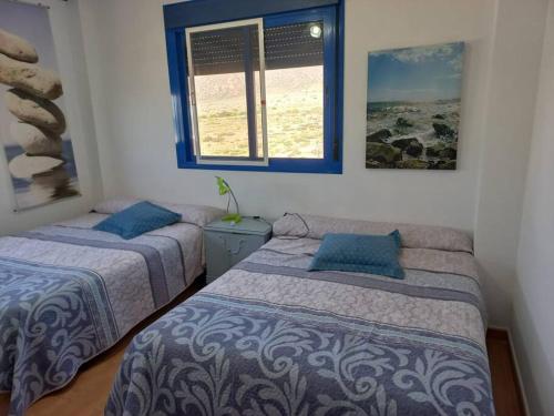 a bedroom with two beds and a window at Casa La Fabriquilla en Cabo de Gata, Almería, Spain in Almería