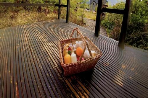 a basket of fruit sitting on a wooden deck at Aos Sí Lodges in Ballachulish