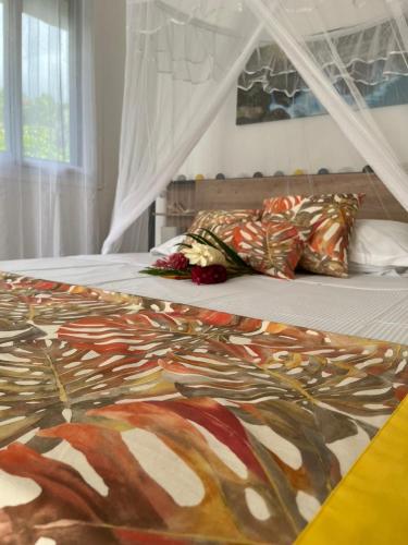 a bed with a colorful blanket and pillows on it at Villa Ti Lanmou in Saint-François