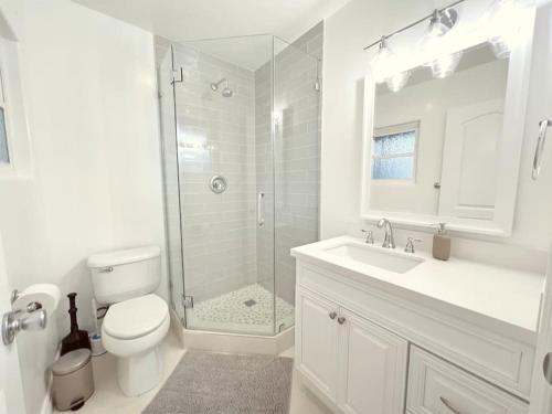 ein Badezimmer mit Dusche, Toilette und Waschbecken in der Unterkunft Historical Beach Bungalow Steps Away From Sand #5 in Newport Beach