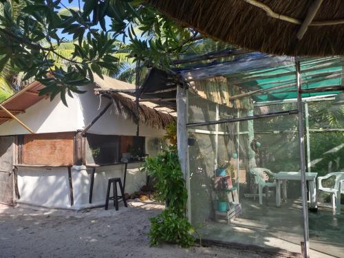an outside view of a house with a table and chairs at Lunazul Eco-Cabaña Frente al Mar in Mahahual
