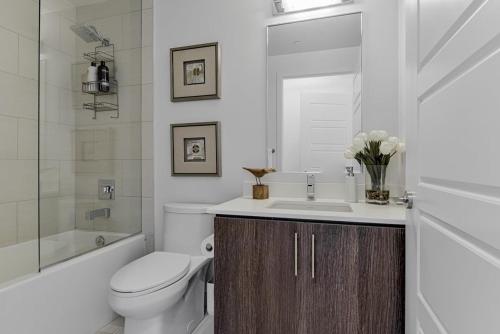 uma casa de banho branca com um WC e um lavatório em Friday Harbour resort apartment em Innisfil