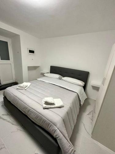 a white bedroom with a large bed with towels on it at Basso Sasà 2 in Naples