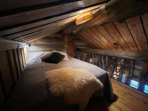 ein Schlafzimmer mit einem Bett in einem Blockhaus in der Unterkunft Ruka Saaruakuja 3 as 1-4 in Ruka