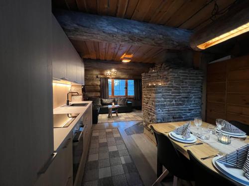 a kitchen and dining room with a table and a stone wall at Ruka Saaruakuja 3 as 1-4 in Ruka
