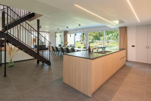an open kitchen and dining room with a staircase at Fluithoekhoeve in Koksijde
