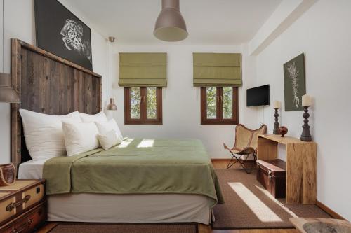 Schlafzimmer mit einem Bett und einem Schreibtisch mit einem TV in der Unterkunft Villa Papis Metsovo in Metsovo