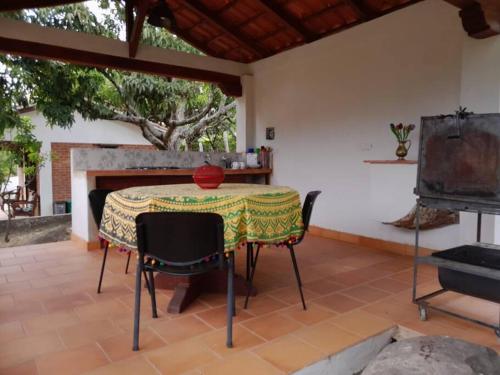 un patio con mesa, sillas y chimenea en Cabaña Colonial Vista Verde, en Tena