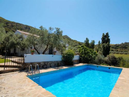 uma piscina em frente a uma casa com uma montanha em Belvilla by OYO Cortijo Los Olivos em La Joya