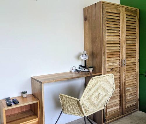 escritorio con silla junto a un armario de madera en Studio -Sand at Mikasa- Fast Internet, King bed, Pool, Near Beach, AC, en Puerto Escondido