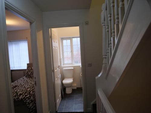 a small bathroom with a toilet and a hallway at Spacious 4 Bed House, Sleep 8 Short & Long Stay, Free Parking ,5min Drive from Man City Stadium in Manchester