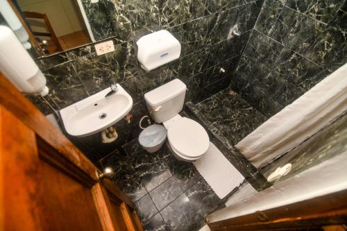 a small bathroom with a toilet and a sink at Hotel Aldea Pura Vida in Puntarenas