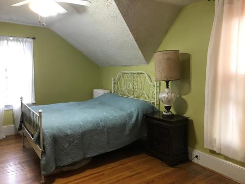 a bedroom with a bed and a lamp on a dresser at ROOM A IN THE WHITE HOUSE in Niagara Falls