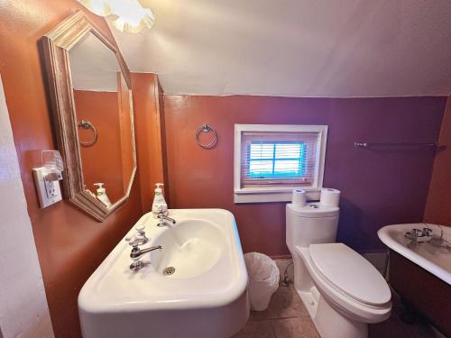 a bathroom with a sink and a toilet and a mirror at ROOM A IN THE WHITE HOUSE in Niagara Falls