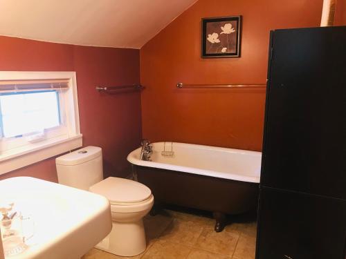 a bathroom with a toilet and a tub and a sink at ROOM A IN THE WHITE HOUSE in Niagara Falls