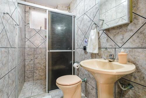 a bathroom with a toilet and a sink and a shower at Confortável apto a 3min da praia de Mariscal CRA304 in Bombinhas