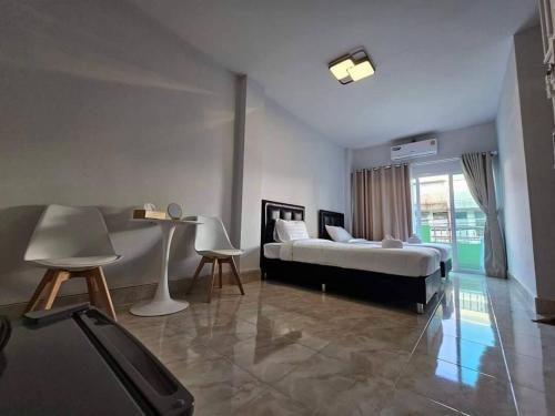 - une chambre avec un lit et une grande fenêtre dans l'établissement Ban Chahomm Guesthouse, à Betong