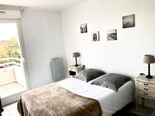 une chambre avec un grand lit et une fenêtre dans l'établissement Côté Bassin, à Arcachon